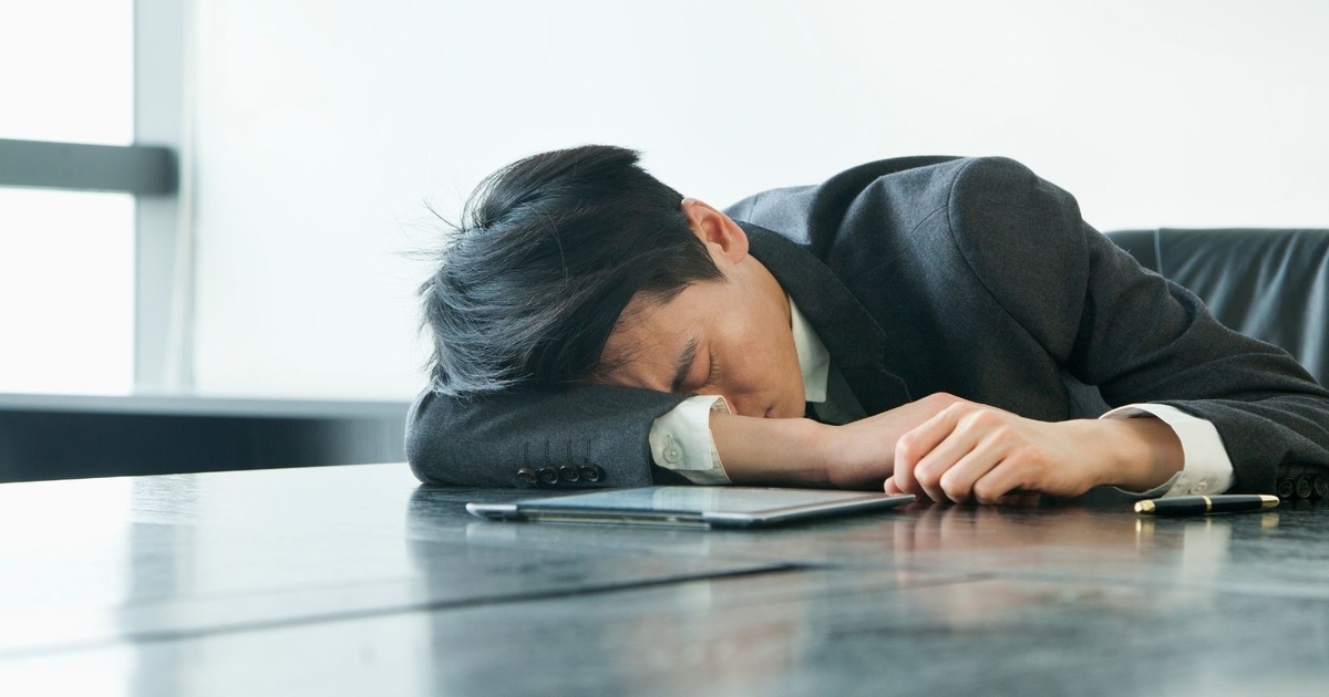 デスクに突っ伏している男性