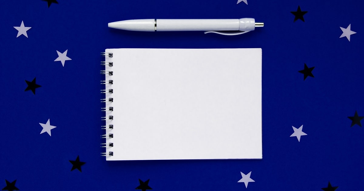 星のイラストを背景にしたメモ帳。就寝前に書く3行ポジティブ日記のイメージ