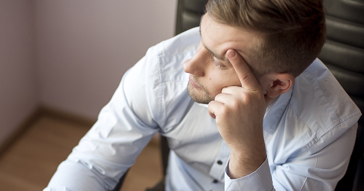 寝不足で不機嫌そうなビジネスパーソン。ネガティブな感情に偏っている様子