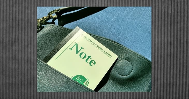 バッグの外ポケットに入った「目に優しいノート」