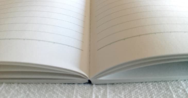 普通のノートの例。真ん中の綴じ部分が膨らんで落ち着かない状態。