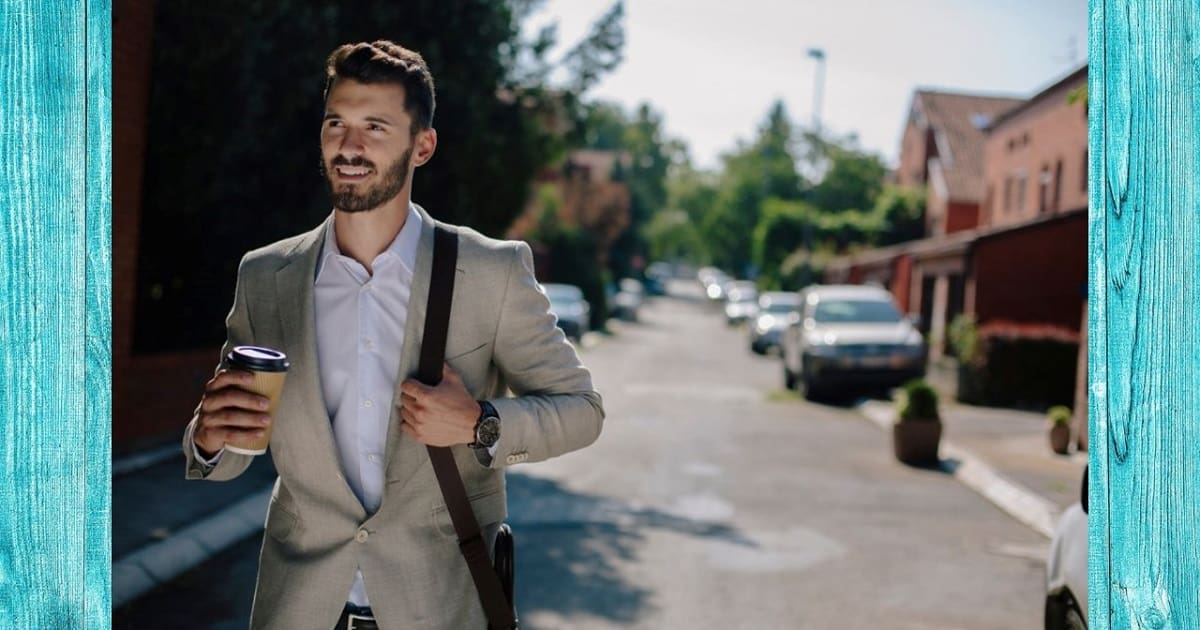 住宅の2階あたりを眺めて姿勢よく歩くビジネスパーソン
