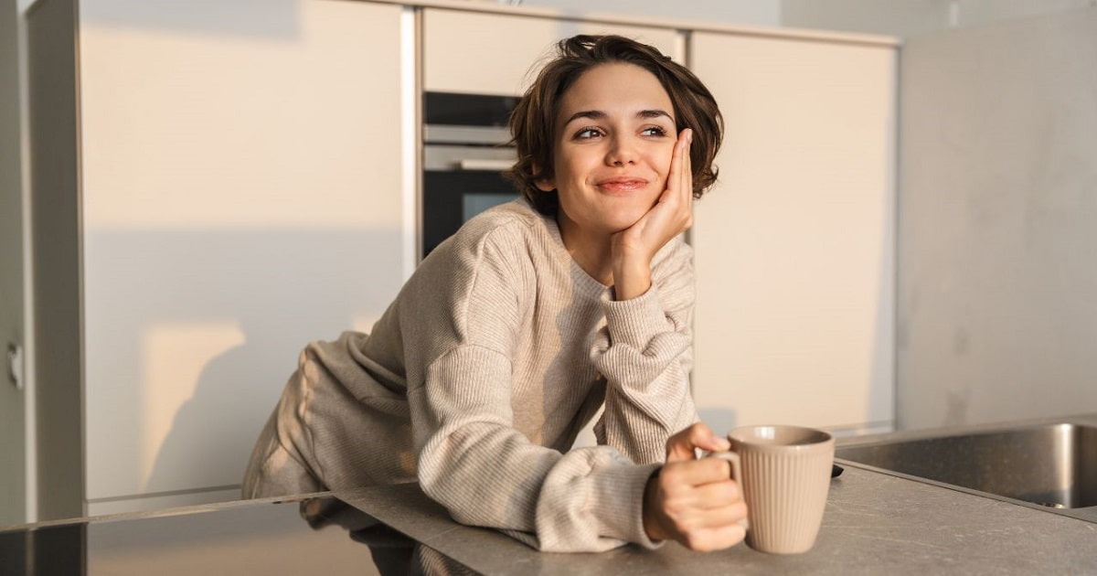朝日を浴び、ポジティブなことを考えながら、コーヒーを飲むビジネスパーソン