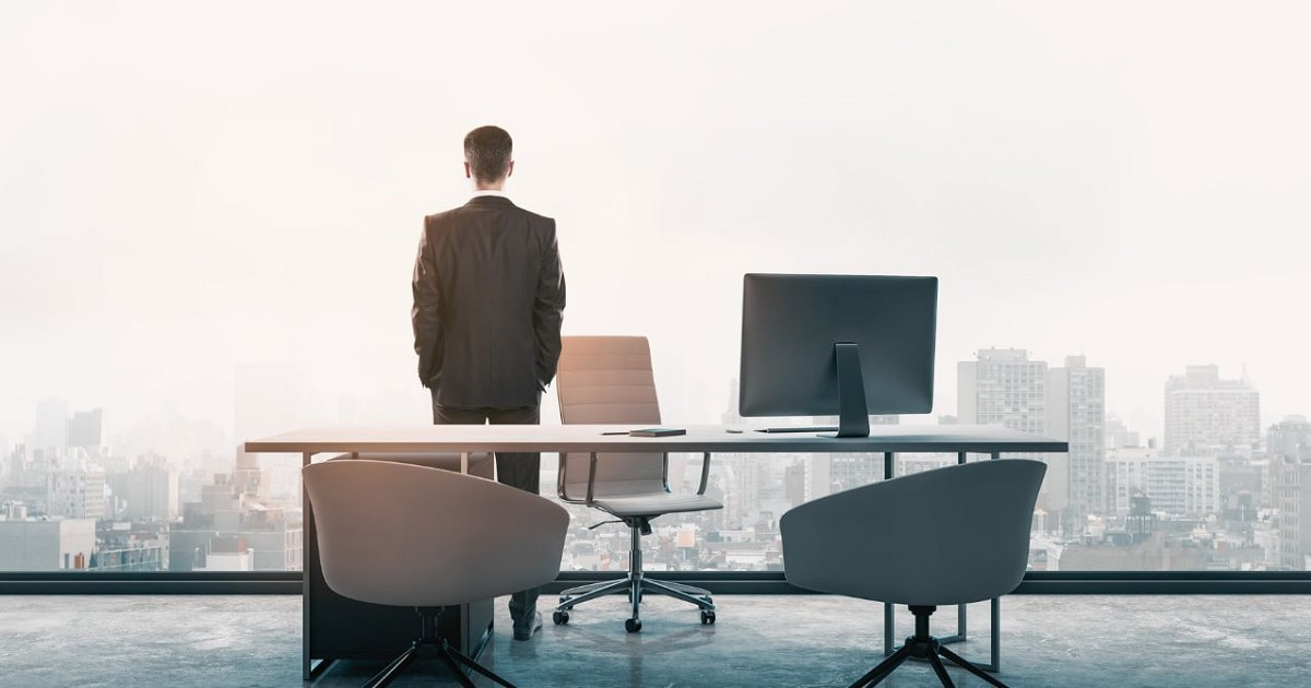 年収1000万円超プレイヤーが高層ビルの高層階オフィスから外を眺めている様子