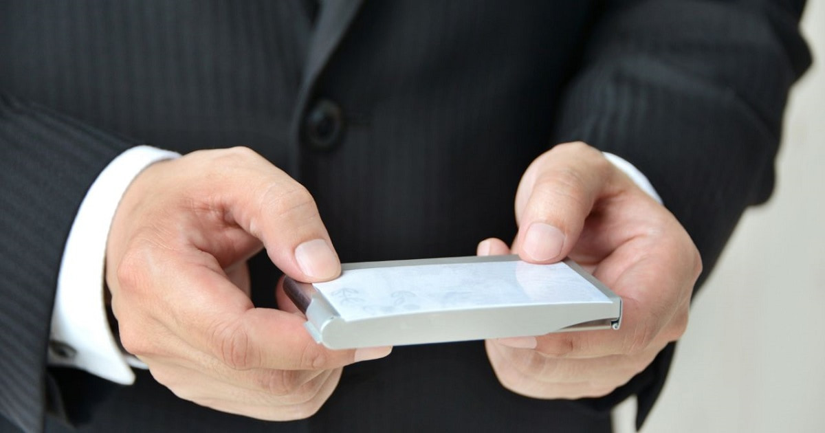 名詞を渡そうとしているビジネスパーソン