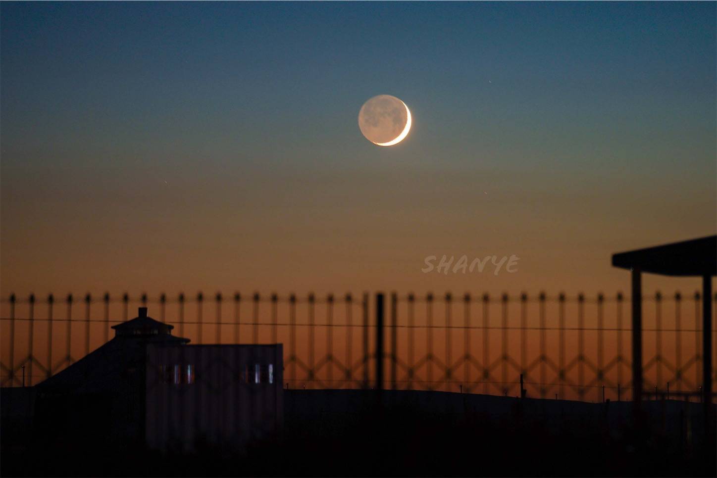 草原の夕日に浮かぶ満月
