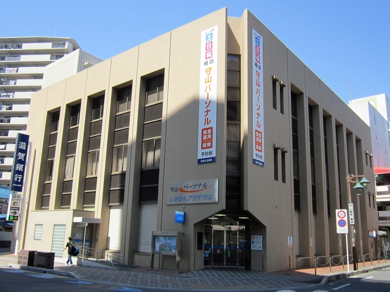 守山の街中に位置する滋賀銀行の支店。地域に根ざした金融サービスを提供している。