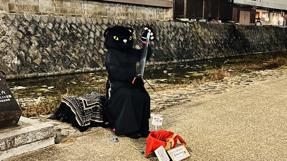 四条大橋の下で二胡を弾くねこ