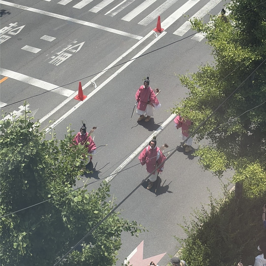 天秤棒で平安の道具を前後に担いで運ぶ人々