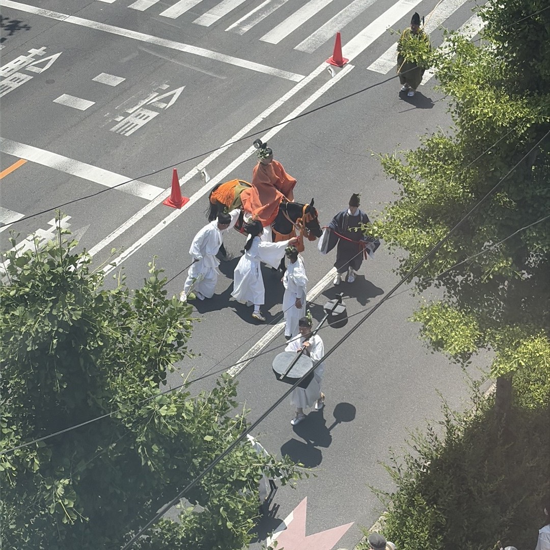 すねた馬をなだめる白装束の3人組