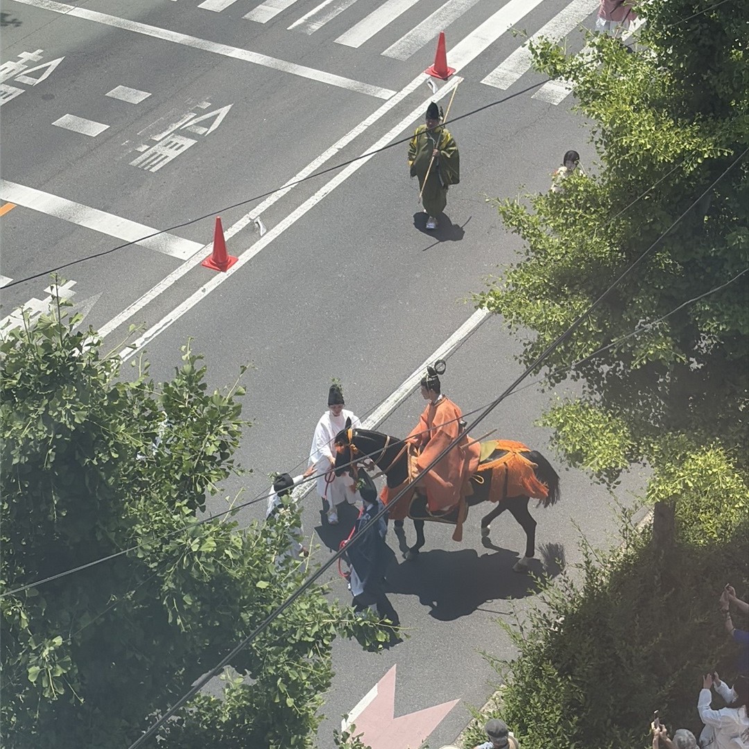 赤とからし色の装束が続く葵祭の行列