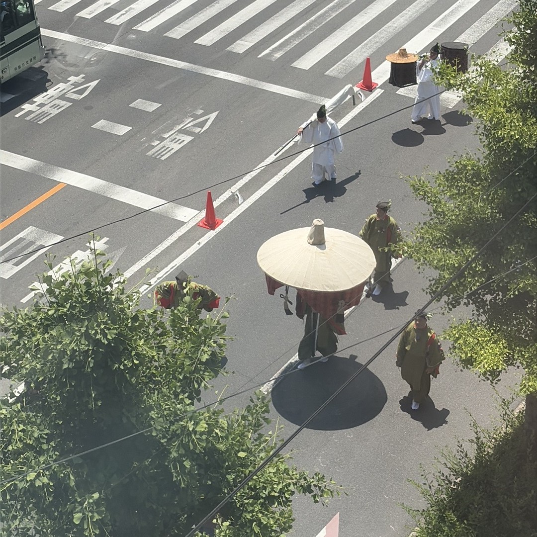 薄紫の装束が斜めに並んで歩く行列