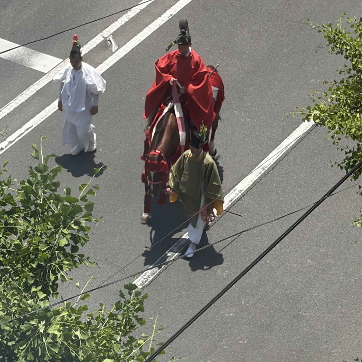 赤装束に栗毛の馬に乗る人物