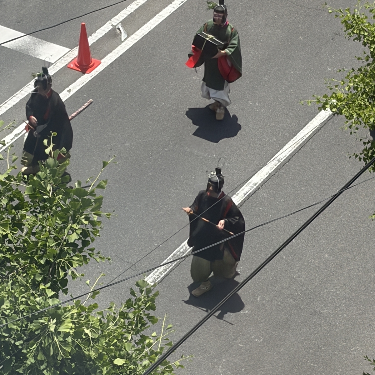 笛や小箱を持った黒装束・緑装束の行列