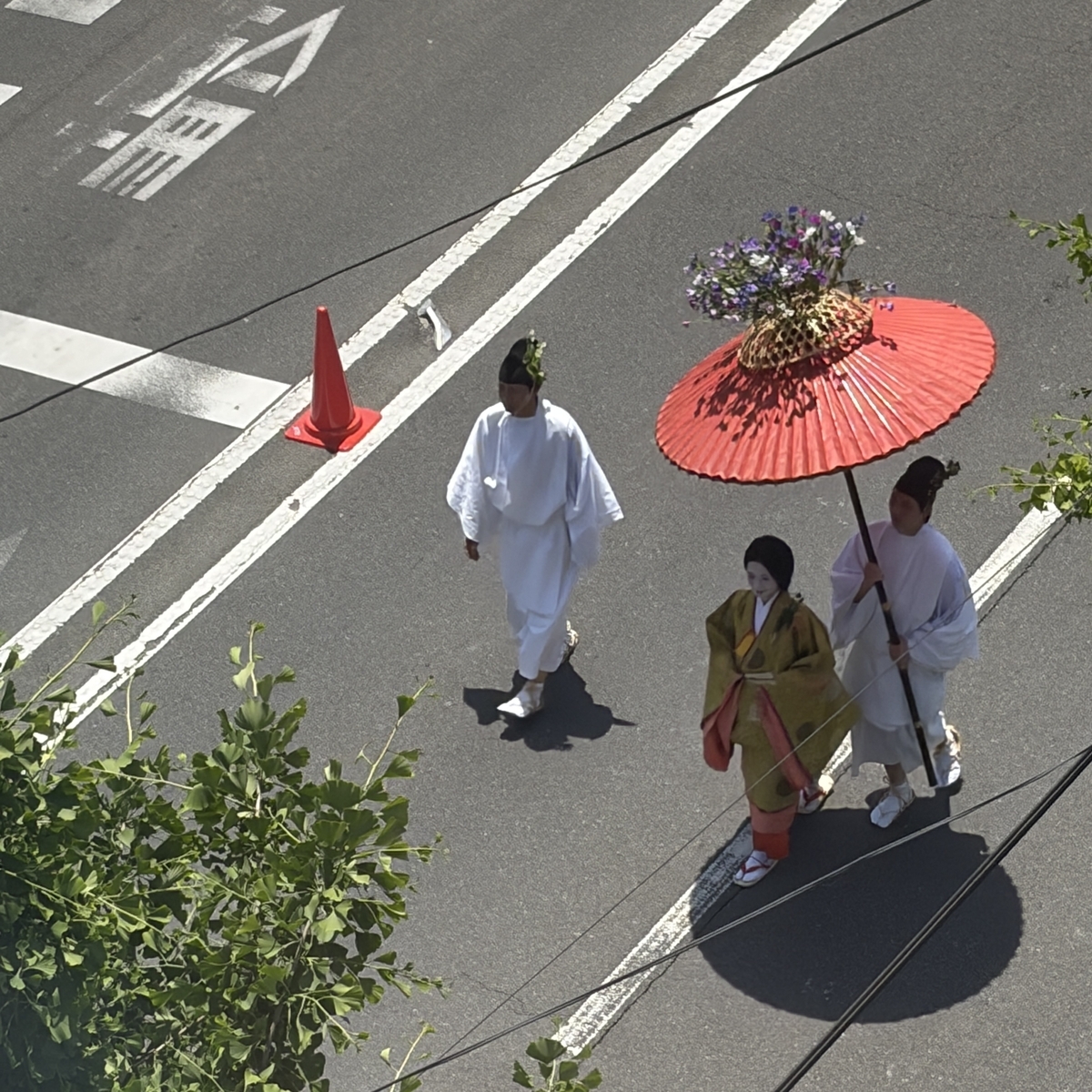 傘の上に花が飾られた行列