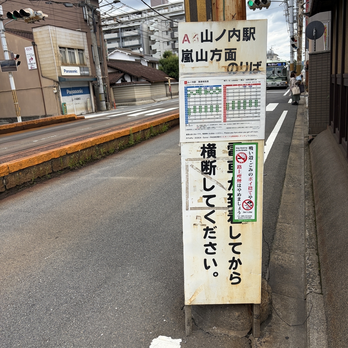 電柱に貼り付けられた駅名看板と時刻表