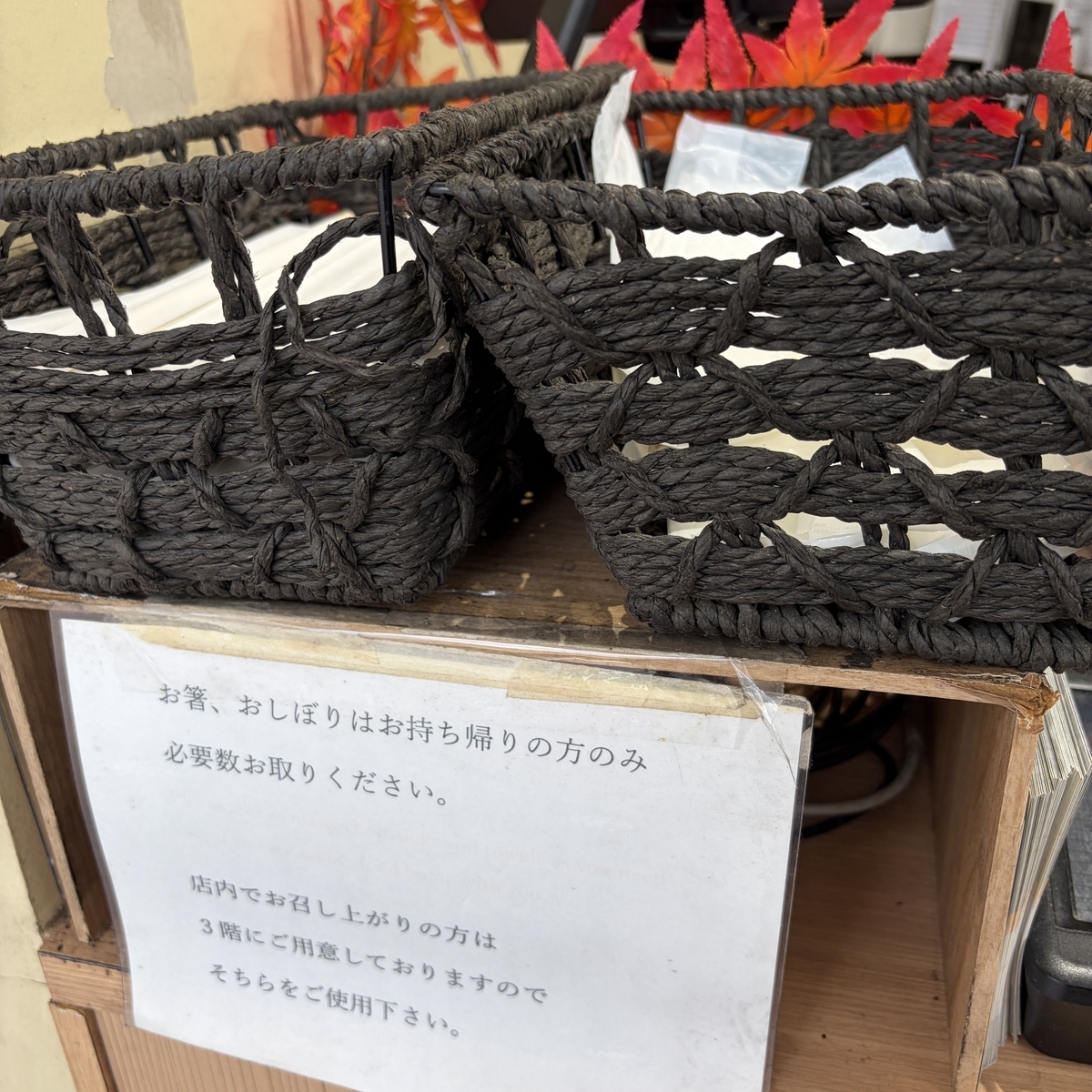 お持ち帰り用のお箸とおしぼりのかごと案内の貼り紙