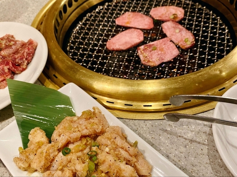 焼肉店でカルビやホルモンなど美味しそうな肉が並べられている。