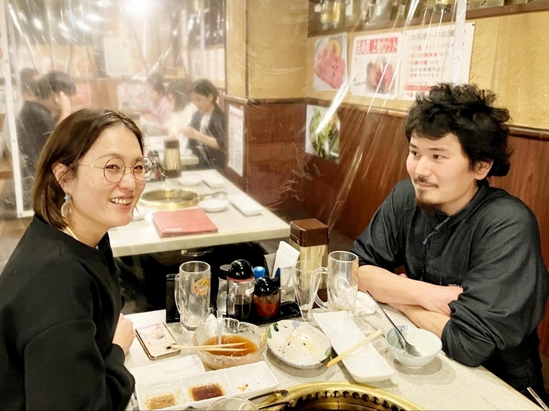 焼肉店で開催された同期会で向き合って歓談している2人の様子