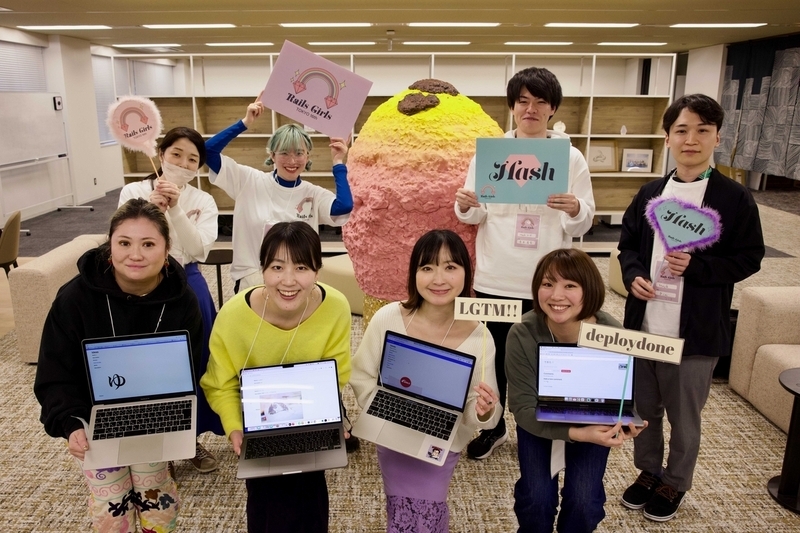 Hashチームの集合写真。8名の男女。前列の4名の女性が作ったアプリをラップトップで表示してこちらに見せている。素敵なサイトが完成しました！