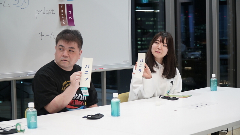 2名の社員がバニラと書かれた札を持っている