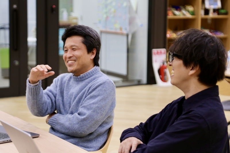 奥がtarappoさん、手前がsaitorycさん。長机に並んでいる。
