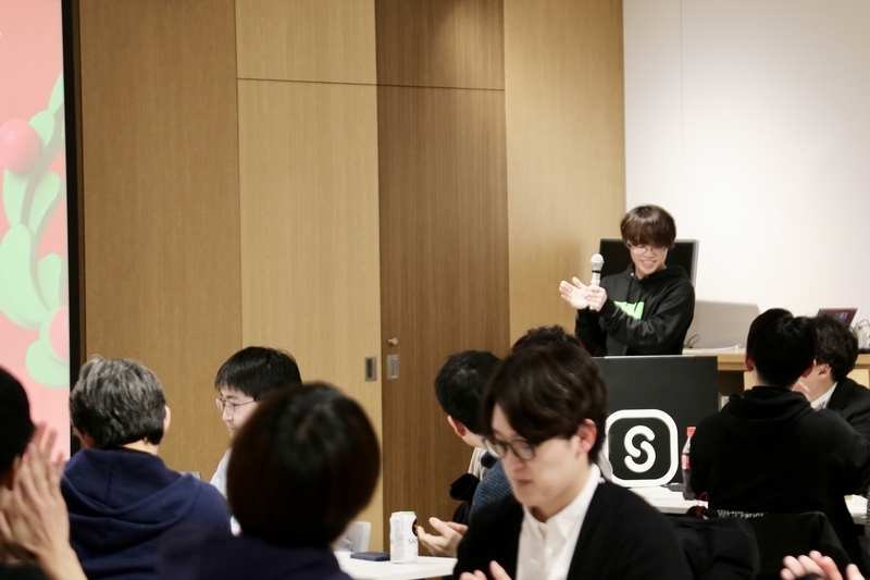 演台に立って拍手で参加者を称える出口さん