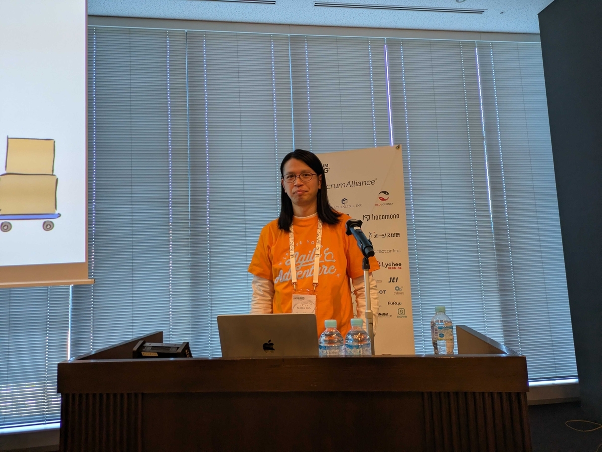発表を終えて放心状態のnomuson。背後にはスポンサーロゴがあり、SmartHRロゴが右下に写っている。