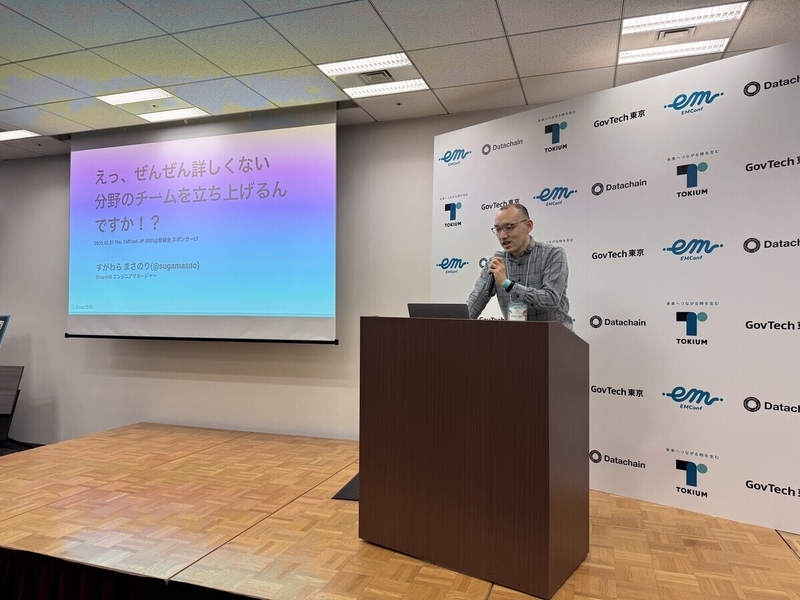 懇親会の会場で男性がスライドを投影し話している様子