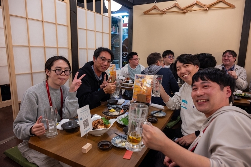 4名の参加者がグラスを掲げて乾杯のポーズを取っている