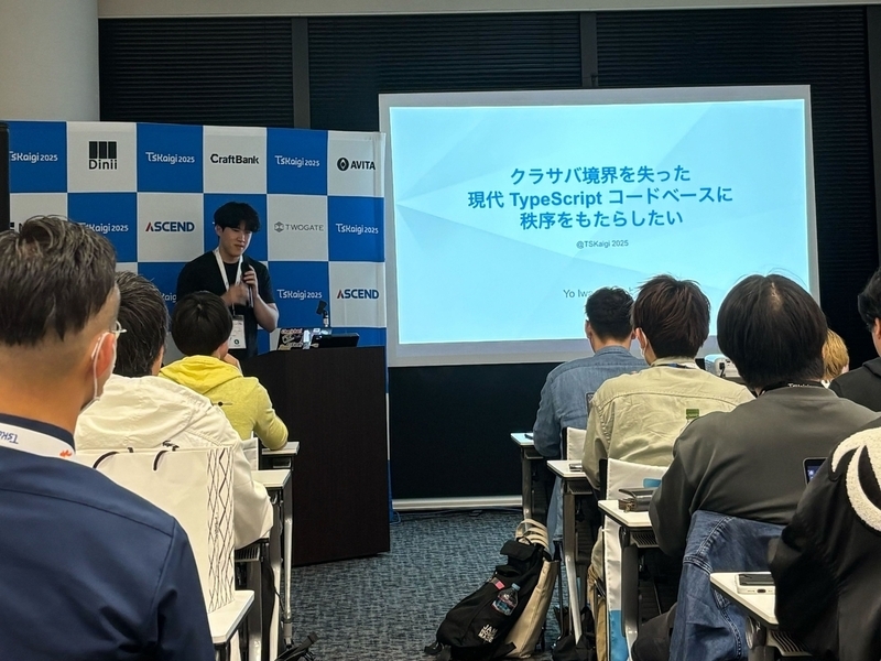 大きなLTスライドパネルの前でマイクを持ちながらろくろを回すYo Iwamotoさん