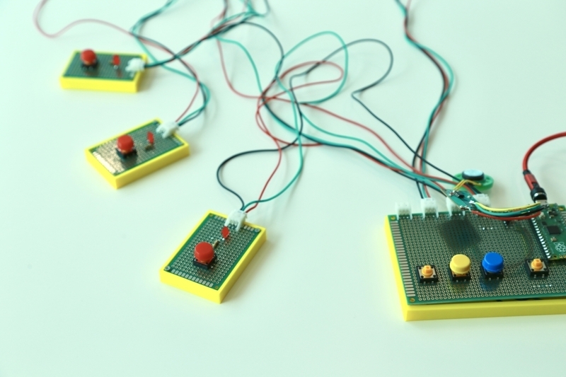 机の上に並べられた３つの早押しボタン