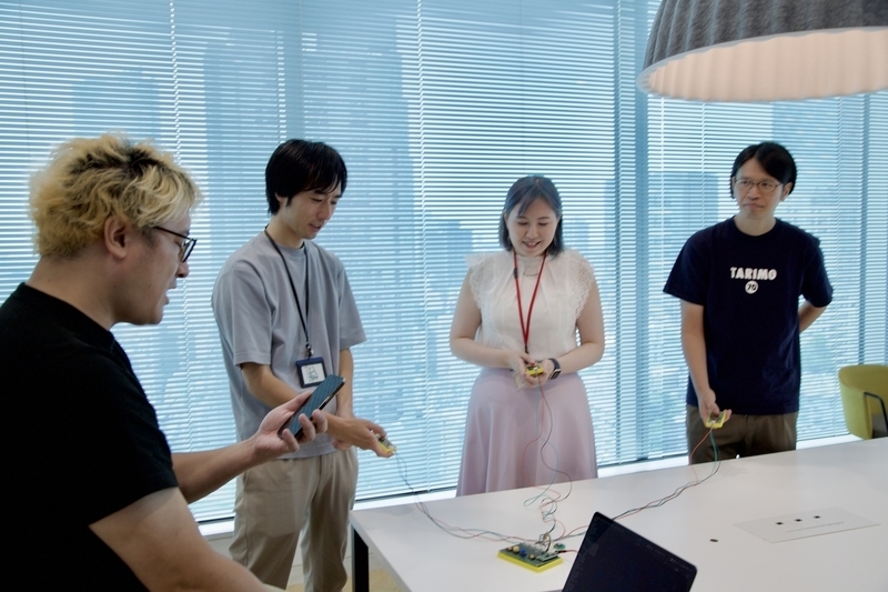 クイズの問題を読み上げる司会と真剣に耳を澄ます3人の写真