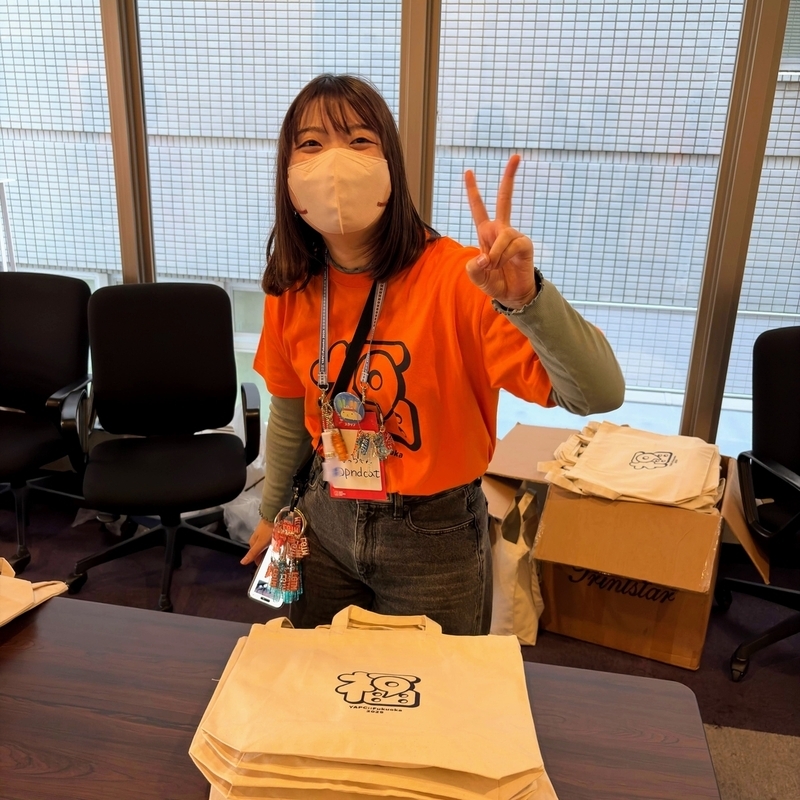 受付でピースをしている