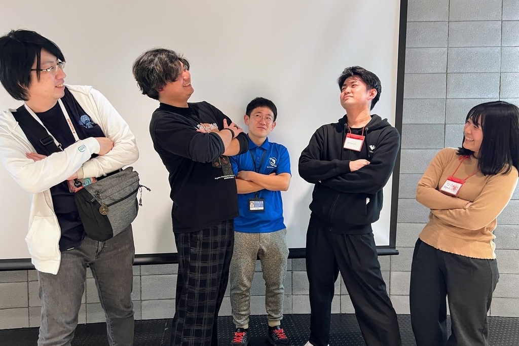 腕を組んで向き合う東西の実行委員たち