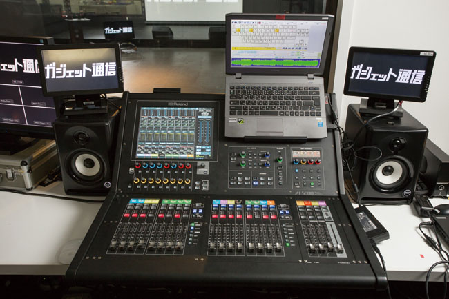 ▲メイン・コンソールのROLAND M-5000C。本体の16イン/8アウトに加え、ステージ・ボックスS-2416がDigital Snakeで接続され、計40インプットを実現。右手のWindowsノートにはポン出し用のソフトが立ち上がっており、ネット経由で送られてくるジングルなどのオーディオ・ファイルを再生し、USBオーディオでM-5000Cに入力している。モニター・スピーカーはRCF Ayra 5