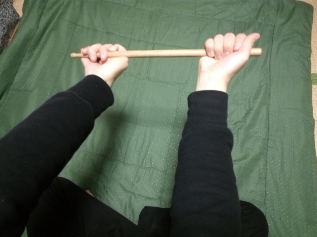 ドラムスティックを持った手の片手をひねる ドラムスティックを持った手の片手をひねる