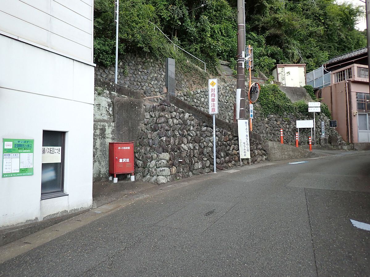 建物の壁に貼られた緑色のポスター状のものがバス停