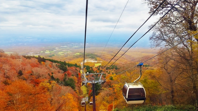 秋の那須ロープウェイから見下ろす那須高原の紅葉景色とゴンドラ