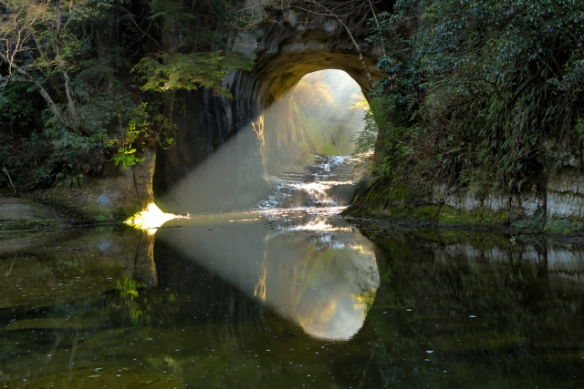 秋の早朝に差し込む光が神秘的な千葉・亀岩の洞窟(濃溝の滝)の観光風景