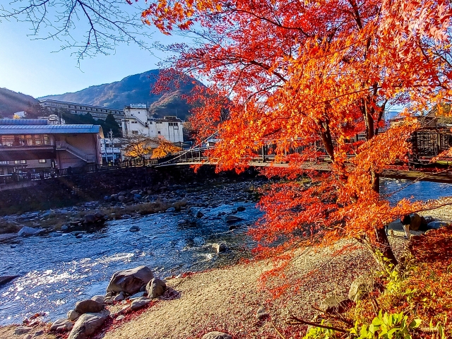 秋の紅葉に彩られた栃木県・塩原温泉郷の箒川渓谷と温泉街の風景