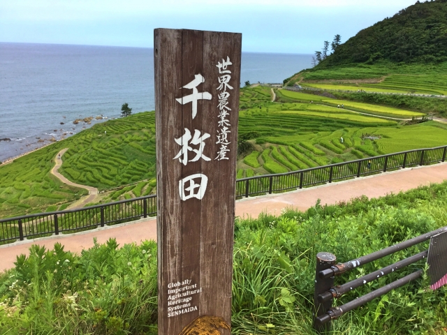 世界農業遺産「千枚田」の看板と日本海へ広がる石川県輪島市の白米千枚田の絶景風景