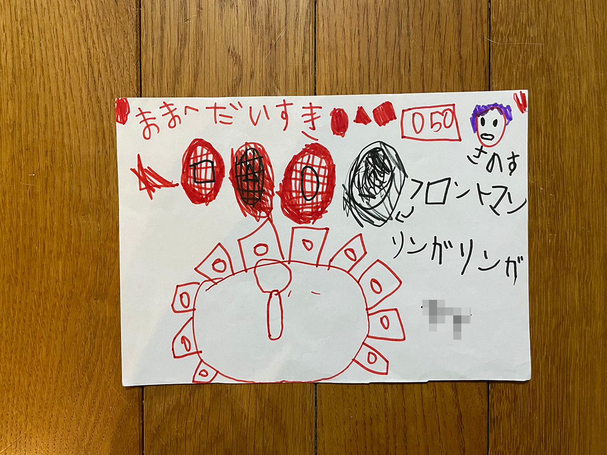 子どもの落書き。絵は関係ない内容だが「ままへ だいすき」と書かれている