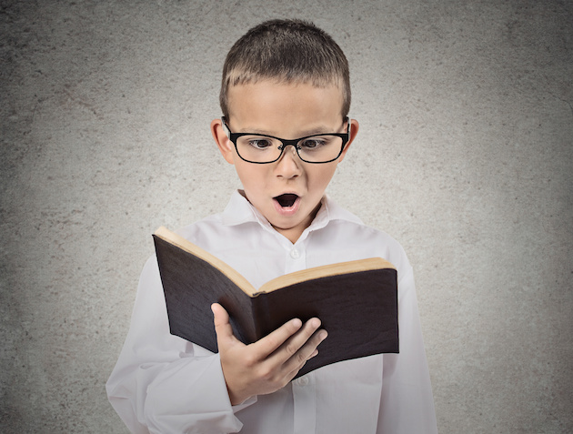 Surprised boy reading book