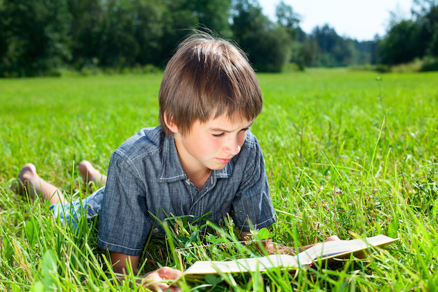 Child reading book outdoor