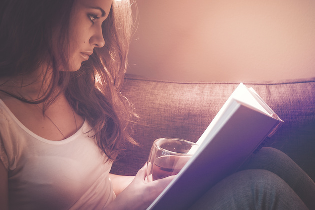 Girl drinks tea and spends time reading books