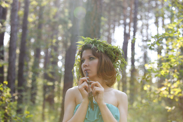 Beautiful model in a forest with a vintage key