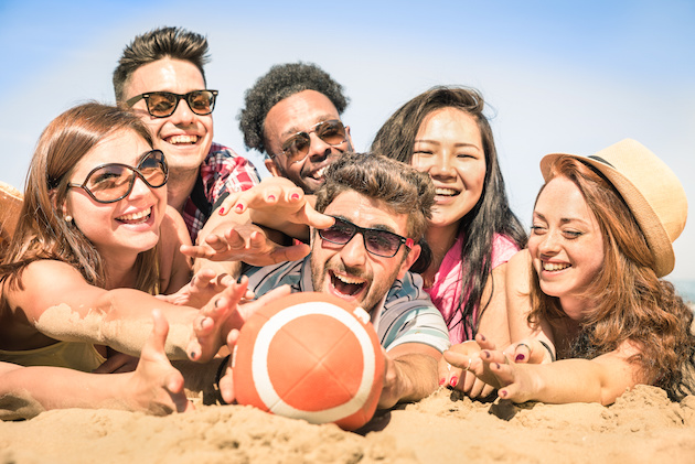 Group of multiracial happy friends having fun at beach games - International concept of summer joy and multi ethnic friendship together - Warm sunny afternoon color tones with shallow depth of field