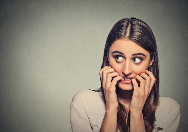 young anxious unsure hesitant nervous woman biting her fingernails