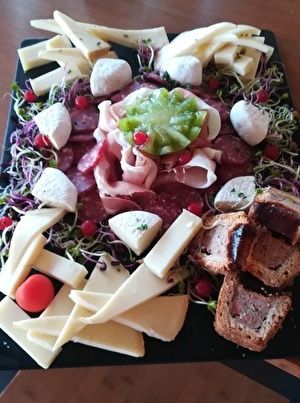 おつまみの盛り合わせ。何種類かのチーズやサラミ、ハム、パテなどがもってある。